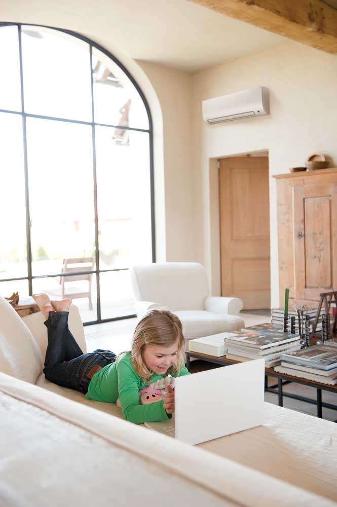 Daikin Comfora binnenunit in een woonkamer, met een kind op de bank
